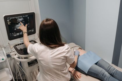 Médica realiza exame de ultrassonografia em uma paciente em consultório.