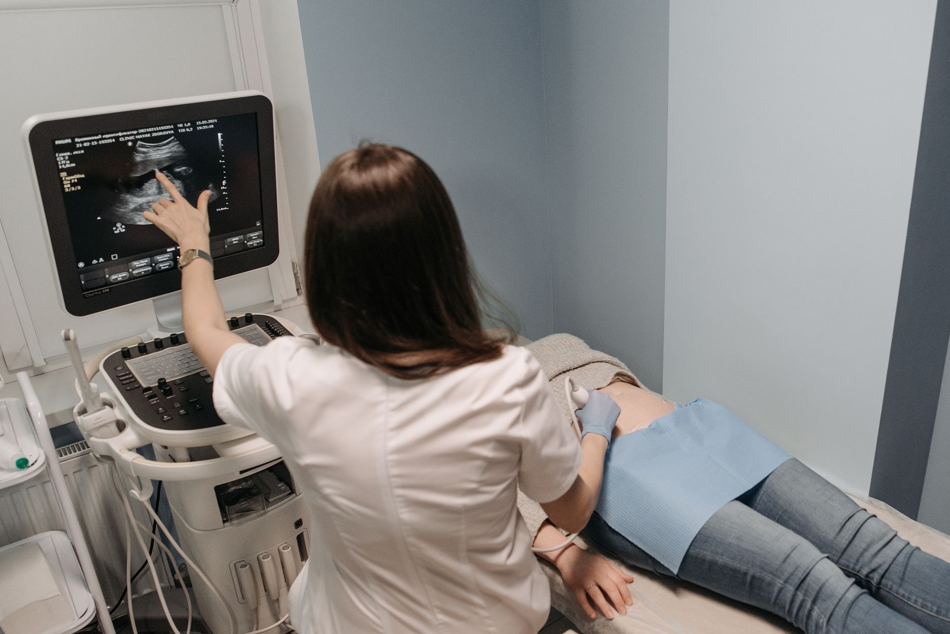 Médica realiza exame de ultrassonografia em uma paciente em consultório.