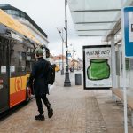 Pessoa embarca em um ônibus elétrico em um ponto de transporte coletivo urbano.