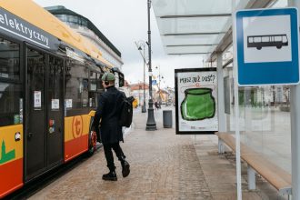Pessoa embarca em um ônibus elétrico em um ponto de transporte coletivo urbano.