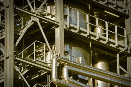 Vista de uma planta industrial com grandes estruturas metálicas e instalações de produção.