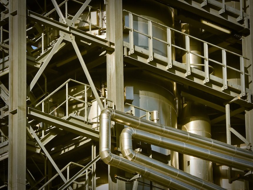 Vista de uma planta industrial com grandes estruturas metálicas e instalações de produção.