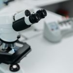 Microscópio em destaque sobre a bancada de um laboratório científico