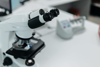 Microscópio em destaque sobre a bancada de um laboratório científico
