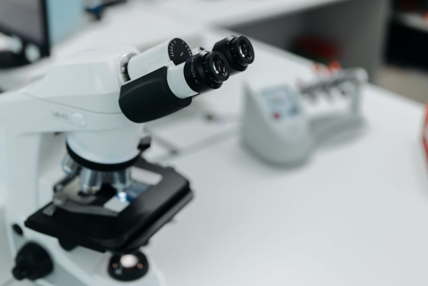 Microscópio em destaque sobre a bancada de um laboratório científico