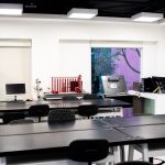 Interior de laboratório educacional contemporâneo, com mesas e equipamentos para atividades de ensino e pesquisa.