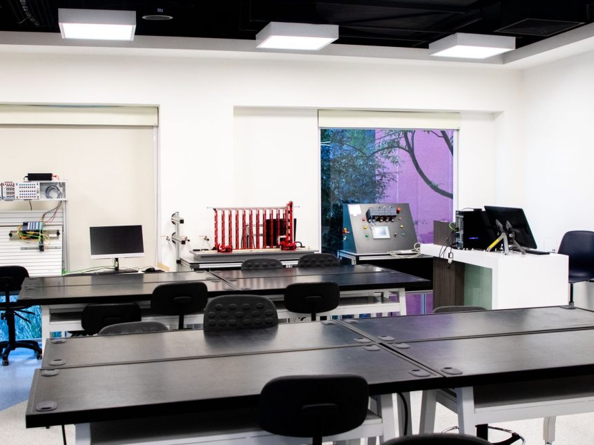 Interior de laboratório educacional contemporâneo, com mesas e equipamentos para atividades de ensino e pesquisa.