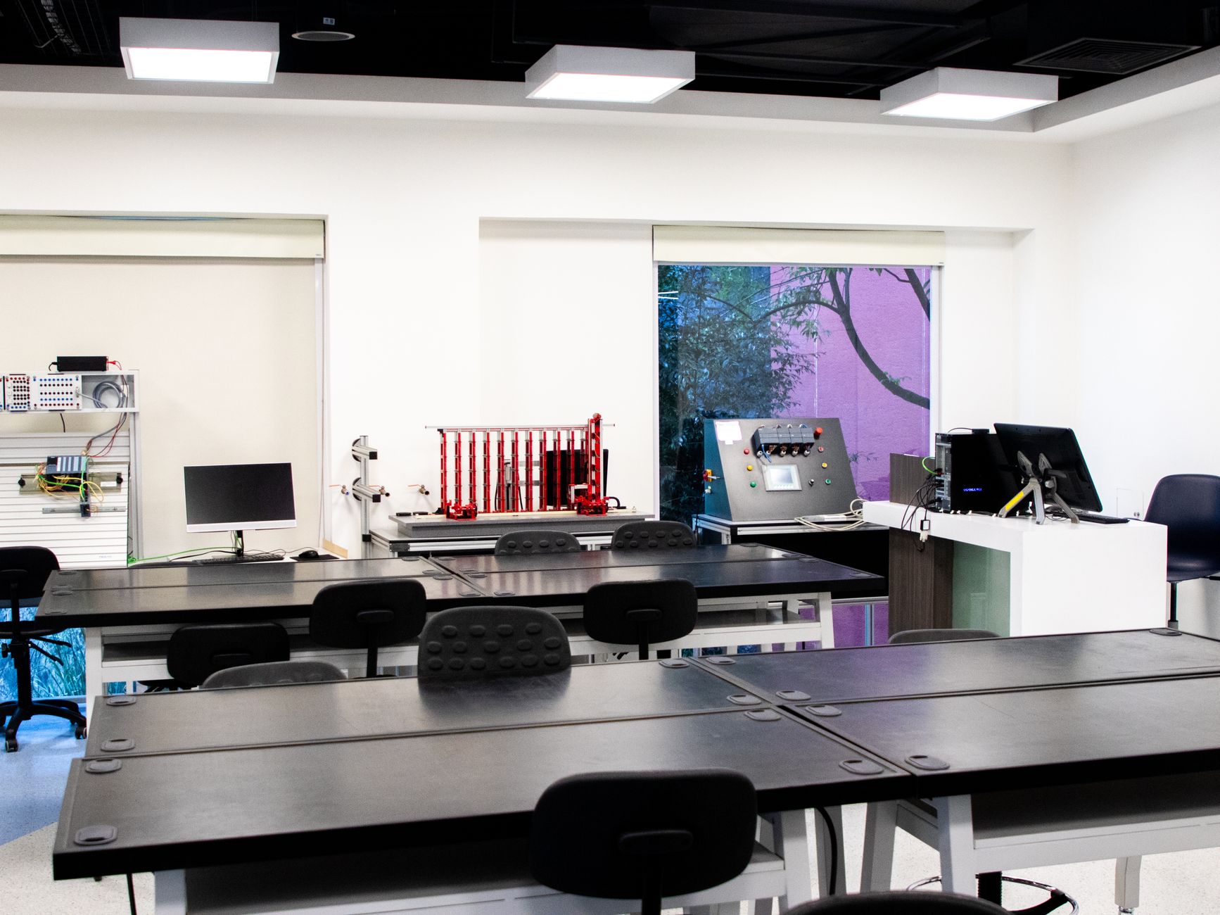 Interior de laboratório educacional contemporâneo, com mesas e equipamentos para atividades de ensino e pesquisa.